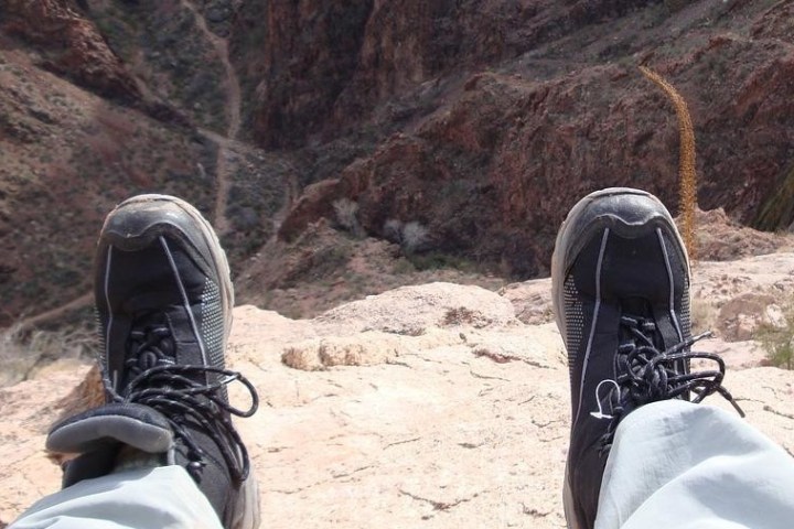 A hiker relaxing in front of a view of the canyon