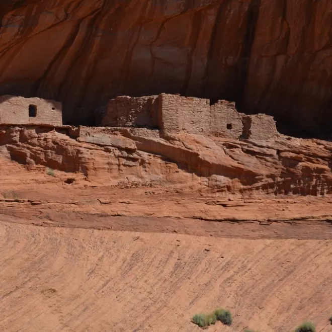 Ruins under a slanted canyon wall